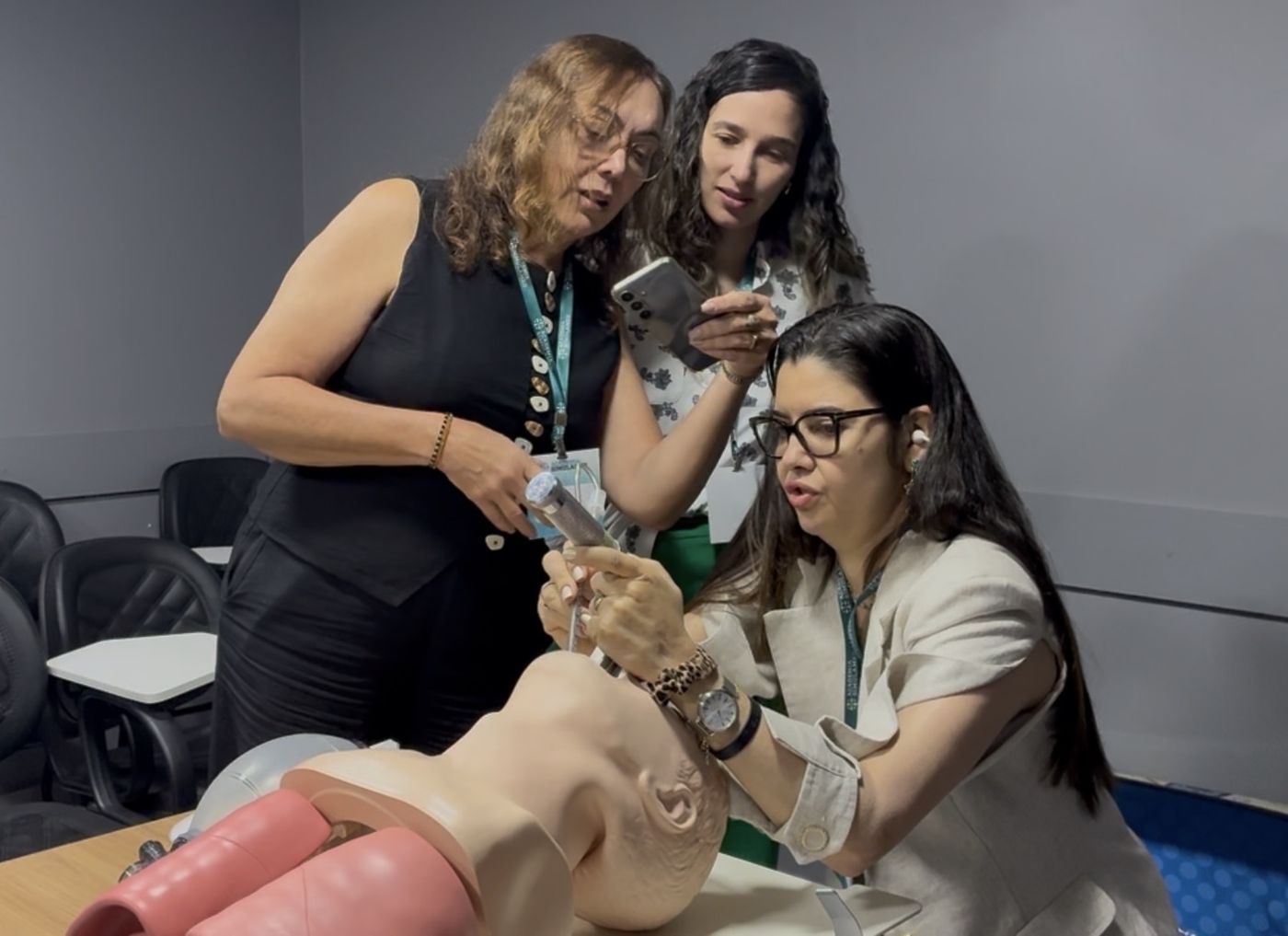 Aluna realizando laringoscopia em manequim enquanto colegas acompanham