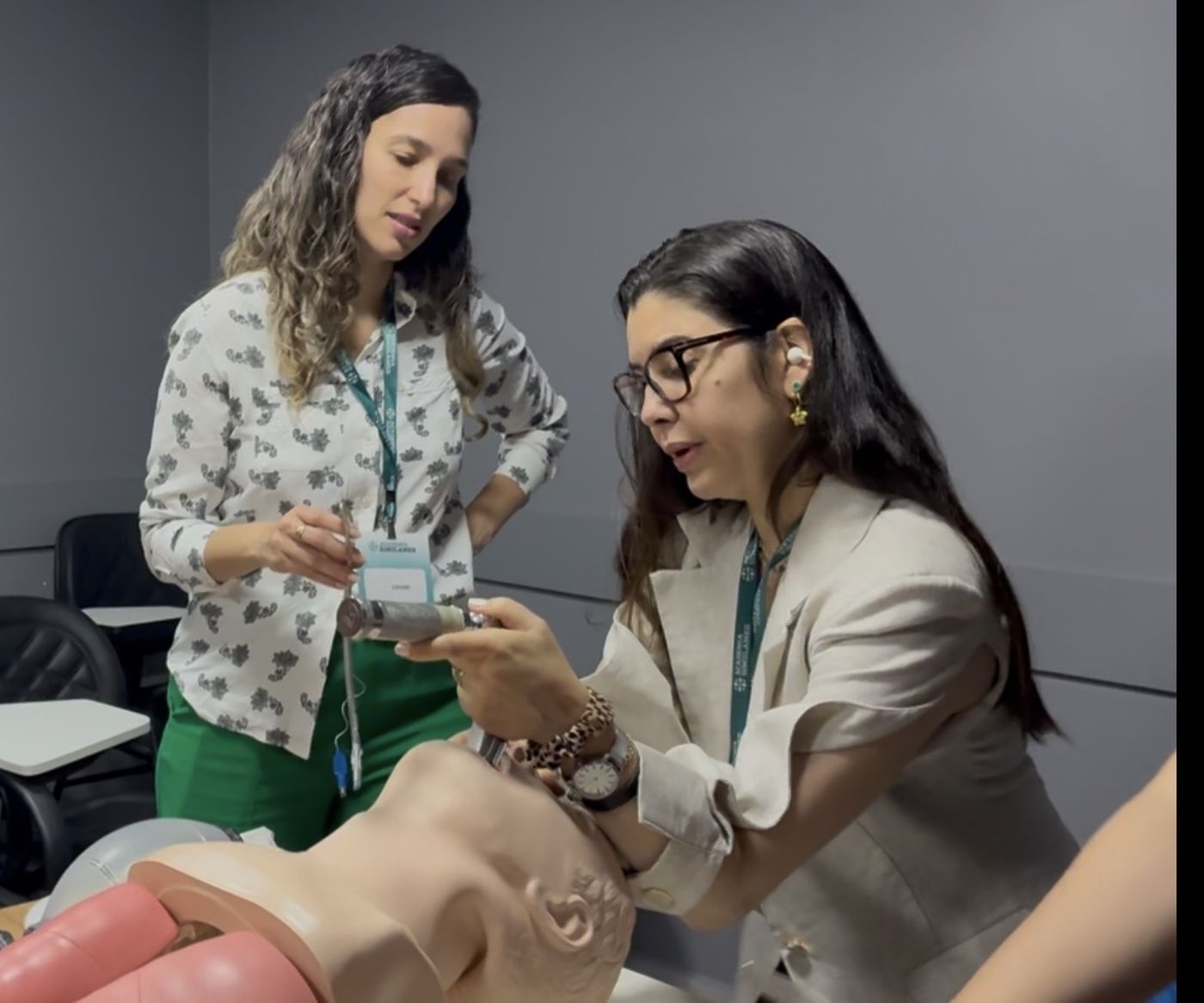 Aluna montando laringoscópio com instrutora ao lado